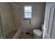 Bathroom with a bath tub and shower, and a window providing natural light at 1017 Grovewood Dr, Beech Grove, IN 46107