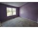 Bedroom with purple walls and a large window providing natural light at 1017 Grovewood Dr, Beech Grove, IN 46107