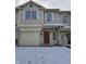 Two story townhome with a red front door and single car garage during the winter at 1017 Grovewood Dr, Beech Grove, IN 46107