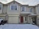 Two story townhome with a red front door and single car garage during the winter at 1017 Grovewood Dr, Beech Grove, IN 46107