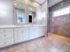 Bright bathroom featuring double sink vanity, mirrors, and glass enclosed tiled shower at 10297 Anees Ln, Fishers, IN 46040
