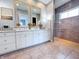 Bright bathroom featuring double sink vanity, mirrors, and glass enclosed tiled shower at 10297 Anees Ln, Fishers, IN 46040