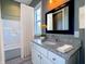 This bathroom has a tub/shower combo and a granite countertop vanity with a black framed mirror at 10297 Anees Ln, Fishers, IN 46040
