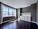 Bedroom featuring large windows, dark walls, hardwood floors and built in shelving and cabinets at 10297 Anees Ln, Fishers, IN 46040