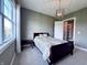 Comfortable carpeted bedroom featuring a window and decorative light fixture at 10297 Anees Ln, Fishers, IN 46040