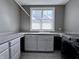 Bright laundry room with sink, washer, gray cabinets, tile flooring, and a window for natural light at 10297 Anees Ln, Fishers, IN 46040