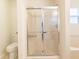 Bathroom with glass enclosed shower, toilet, and window with natural light at 11005 Long Lake Ln, Fishers, IN 46037