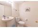 A half bathroom has a pedestal sink, white toilet, and a colorful 'All you need is love' art print at 11005 Long Lake Ln, Fishers, IN 46037