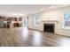 Open-concept living area with hardwood floors, a fireplace, and seamless access to the kitchen at 11005 Long Lake Ln, Fishers, IN 46037
