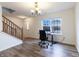 A well-lit room showcases desk, and stairs with wood railing leading to another level in home at 11005 Long Lake Ln, Fishers, IN 46037