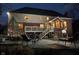 A back patio and backyard at dusk with a pool and comfortable seating at 11727 Windpointe Pass, Carmel, IN 46033