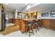 Basement bar with wood counters, wooden bar stools and bar shelving with glass doors at 11727 Windpointe Pass, Carmel, IN 46033