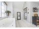 Bathroom with a luxurious soaking tub, walk-in shower, neutral tile, and a large mirror for added light at 11727 Windpointe Pass, Carmel, IN 46033
