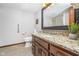 Charming bathroom featuring granite countertop, wood cabinets, and decorative mirror at 11727 Windpointe Pass, Carmel, IN 46033