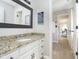 Bathroom featuring a granite-topped vanity, a large mirror, and a hallway view to an office space at 11727 Windpointe Pass, Carmel, IN 46033