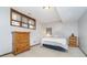 Bedroom with wood dresser, neutral carpet, and a bed beneath a window with wood trim at 11727 Windpointe Pass, Carmel, IN 46033