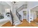 Inviting foyer with hardwood floors, a staircase with a dark railing, and neutral walls at 11727 Windpointe Pass, Carmel, IN 46033