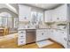 Bright kitchen features white cabinets, stainless steel appliances, granite counters and hardwood floors at 11727 Windpointe Pass, Carmel, IN 46033