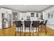 Beautiful kitchen features white cabinetry, stainless steel appliances, and a spacious island with bar stool seating at 11727 Windpointe Pass, Carmel, IN 46033