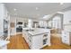 Spacious kitchen with a large center island, breakfast bar, white cabinetry, and hardwood floors at 11727 Windpointe Pass, Carmel, IN 46033