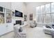 Inviting living room with built-in shelves, a cozy fireplace, and large windows showcasing outdoor views at 11727 Windpointe Pass, Carmel, IN 46033