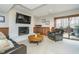 Living room with white fireplace, wood paneling, leather chairs, and sliding glass doors to patio at 11727 Windpointe Pass, Carmel, IN 46033