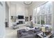 Bright living room features a white brick fireplace, built-in shelving, and large windows with views of the wooded property at 11727 Windpointe Pass, Carmel, IN 46033
