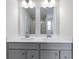 Bathroom featuring double vanity with gray cabinets, a framed mirror, and a glass enclosed shower at 1202 Brightwood Cir, Greenfield, IN 46140