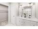 Bright bathroom with double vanity, white cabinets and a tiled shower at 1202 Brightwood Cir, Greenfield, IN 46140