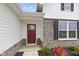 Close up view of the front entrance of the home, which includes a red front door, stone accents, and landscaping at 1202 Brightwood Cir, Greenfield, IN 46140