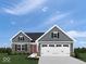 Charming single-Gathering home featuring stone accents, a two-car garage, and a well-manicured lawn at 1202 Brightwood Cir, Greenfield, IN 46140
