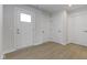 Hallway showing modern flooring with white doors and trim, enhancing a bright and functional design at 1202 Brightwood Cir, Greenfield, IN 46140