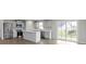 Spacious kitchen with stainless steel appliances, white cabinets, and a large center island, opening to a sliding glass door at 1202 Brightwood Cir, Greenfield, IN 46140