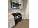 New stainless steel gas range and microwave complement the modern kitchen design at 1202 Brightwood Cir, Greenfield, IN 46140