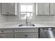 Bright kitchen area with white quartz counters, stainless steel sink, shaker cabinets, and modern fixtures at 1202 Brightwood Cir, Greenfield, IN 46140