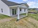 An outdoor patio features white columns, a concrete floor, and a sliding glass door to access the home at 1202 Brightwood Cir, Greenfield, IN 46140