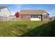 Exterior view of the home's backyard with green grass, brick siding, and a screened-in porch at 14461 Brook Meadow Dr, McCordsville, IN 46055