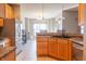 Bright kitchen with wooden cabinets, stainless steel refrigerator, and an open view into the dining area at 14461 Brook Meadow Dr, McCordsville, IN 46055