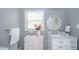 Charming bathroom with marble countertops, a decorative round mirror, and a bright window at 1718 Charles St, Anderson, IN 46013