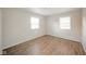 Spacious bedroom with wood-look floors and natural light from two bright windows at 1718 Charles St, Anderson, IN 46013