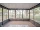 Bright sunroom with large windows offering backyard views, and a neutral area rug at 1718 Charles St, Anderson, IN 46013