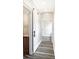 Hallway leading to a bathroom, showcasing vinyl floors, a sliding barn door, and neutral walls at 1933 Koehne St, Indianapolis, IN 46202