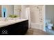 Bathroom with a tub-shower combo, double sinks, dark cabinets, and modern fixtures at 2452 Bristol Dr, Franklin, IN 46131