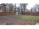 Wide open backyard with a wooden fence, a small playhouse, and a large tree at 3121 W 13Th St, Anderson, IN 46011