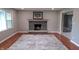 Cozy living room with brick fireplace, wooden mantle, and hardwood floors at 3121 W 13Th St, Anderson, IN 46011
