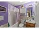 Bathroom with shower-tub combo, vanity with sink, lavender walls, and decorative curtains at 4038 Oak Trail Dr, Indianapolis, IN 46237