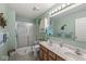 Bathroom featuring a shower with glass door, wood vanity with dual sinks, and light green walls at 4038 Oak Trail Dr, Indianapolis, IN 46237