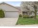 Charming single-story home features a well-manicured lawn, mature flowering tree, and a two-car attached garage at 4038 Oak Trail Dr, Indianapolis, IN 46237