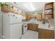 Efficient kitchen offers wood cabinets, white appliances, neutral countertops, tiled backsplash and flooring at 4038 Oak Trail Dr, Indianapolis, IN 46237