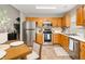 Eat-in kitchen with oak cabinets, stainless appliances, and a dining area by a large window at 4619 Churchill Downs Cir, Greenwood, IN 46143